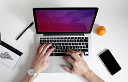 Individueller Stromverbrauch vom PC Eine Person hat die Hände auf der Tastatur eines Laptops.