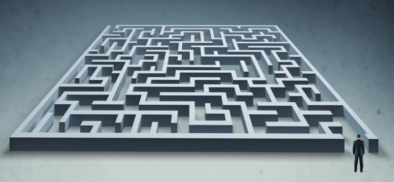Welche Stromanbieter gehören zusammen? Mann im Anzug steht vor einem Labyrinth