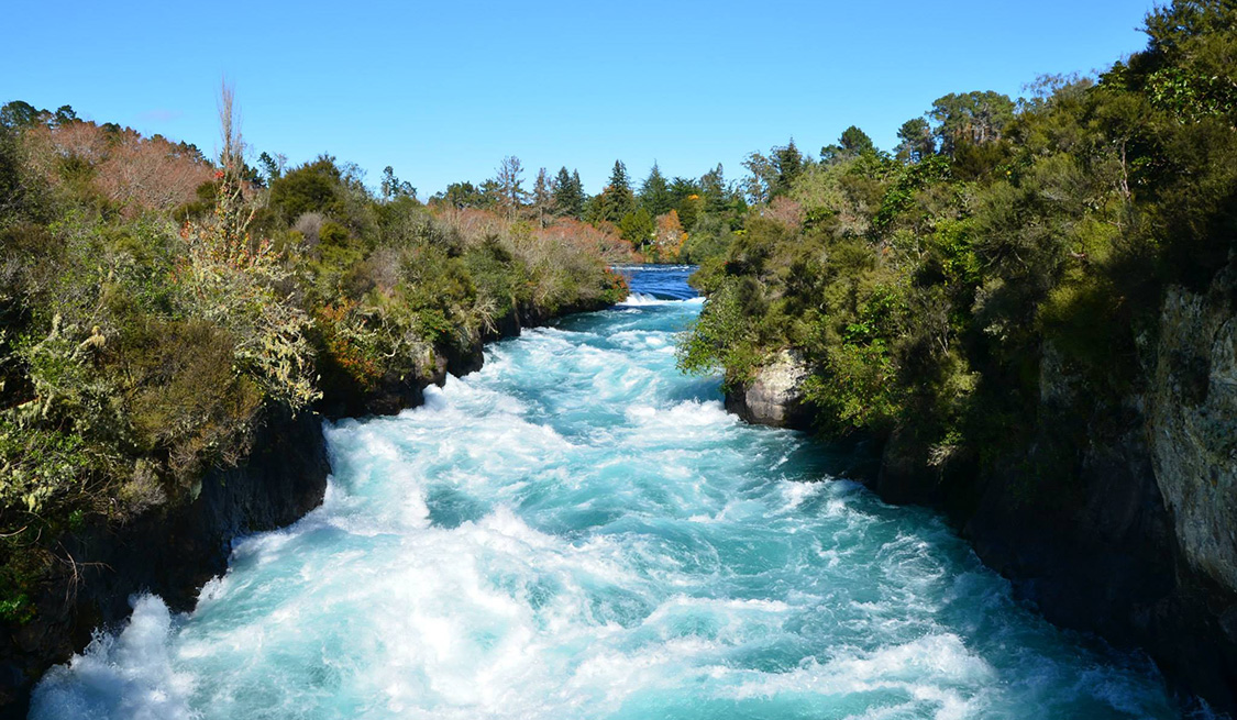 Wasserkraft | Erneuerbare Energien Wasserkraft | ErEin reißender Fluss, links und rechts Steinklippen und Grüngewächse.