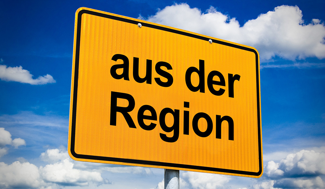 Regionaler Stromanbieter im Preischeck – Verbraucherthemen Ortsschild mit der Aufschrift "aus der Region" mit blauem Wolkenhimmel im Hintergrund