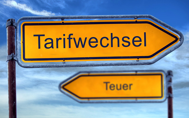 Zwei Schilder zeigen in entgegengesetzte Richtung mit den Aufschriften Tarifwechsel und Teuer.