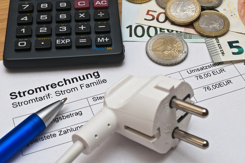 Stromabrechnung Stromrechnung mit Stift, Taschenrechner und Bargeld danebenliegend